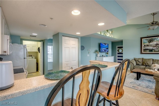 16641 Stringfellow Rd Unit 506, Bokeelia, FL 33922 - kitchen with washer / clothes dryer, white cabinetry, recessed lighting, a breakfast bar area, and ceiling fan