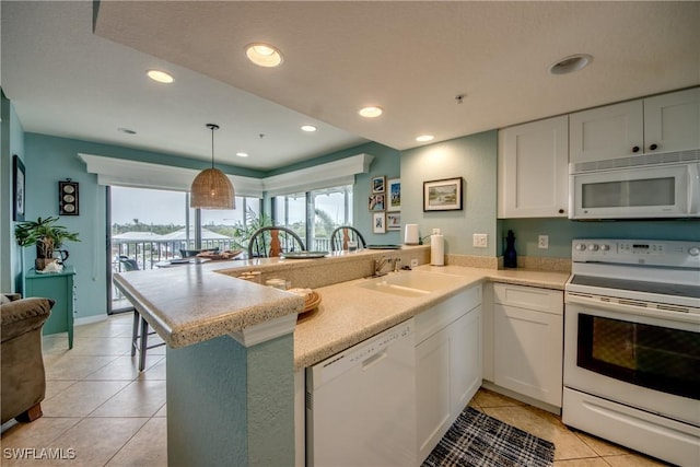 16641 Stringfellow Rd Unit 506, Bokeelia, FL 33922 - kitchen featuring white appliances, a sink, a peninsula, light tile patterned floors, and light countertops