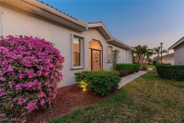 10412 Materita Dr, Fort Myers, FL 33913 - property exterior at dusk with stucco siding and a lawn