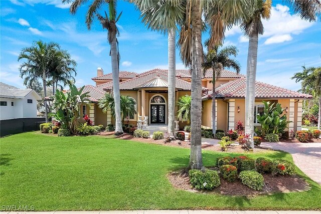 1658 Mcilvaine Ct, Marco Island, FL 34145 - mediterranean / spanish house featuring stucco siding, a tiled roof, a front lawn, and a chimney
