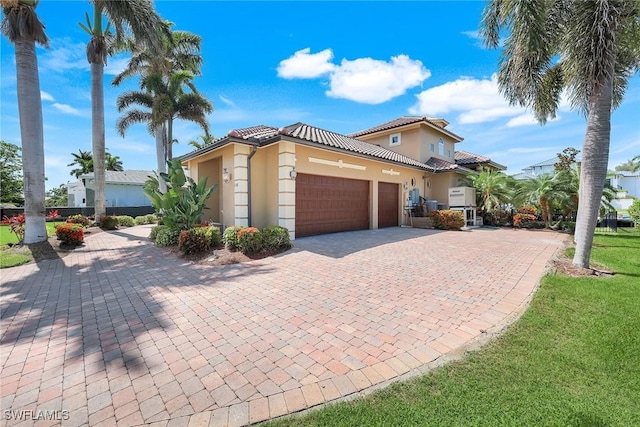 1658 Mcilvaine Ct, Marco Island, FL 34145 - mediterranean / spanish-style house featuring a garage, stucco siding, decorative driveway, and a front lawn