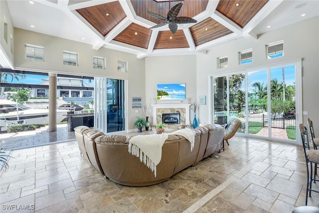 1658 Mcilvaine Ct, Marco Island, FL 34145 - living area with a high ceiling, stone tile flooring, coffered ceiling, a ceiling fan, and wooden ceiling with exposed beams