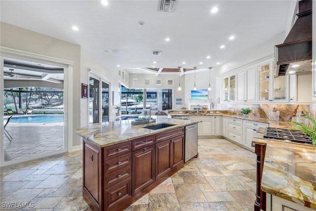 1658 Mcilvaine Ct, Marco Island, FL 34145 - kitchen featuring a sink, stone tile floors, dishwasher, wall chimney exhaust hood, and recessed lighting
