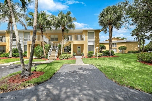1250 Yesica Ann Cir Unit E106, Naples, FL 34110 - view of property featuring stairs, a front lawn, and stucco siding