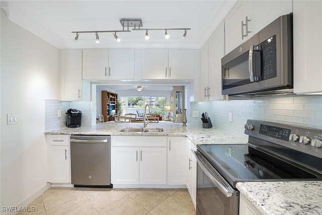 1250 Yesica Ann Cir Unit E106, Naples, FL 34110 - kitchen featuring stainless steel appliances, a sink, white cabinets, light tile patterned floors, and light stone countertops