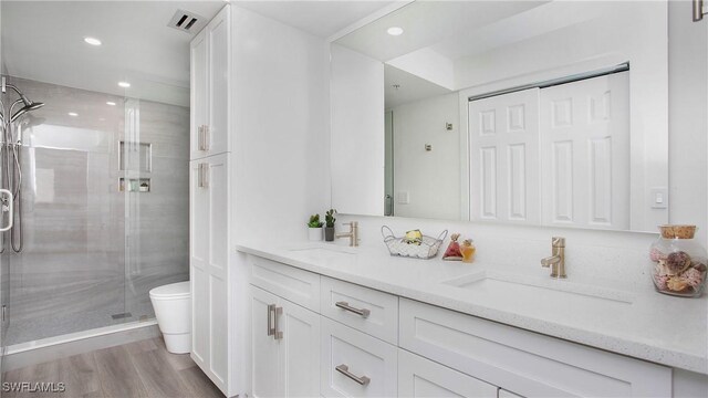 9640 Victoria Ln Unit C308, Naples, FL 34109 - full bath featuring double vanity, toilet, a shower stall, recessed lighting, and wood finished floors