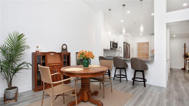 9640 Victoria Ln Unit C308, Naples, FL 34109 - dining room with light wood-type flooring, baseboards, high vaulted ceiling, and recessed lighting