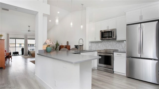 9640 Victoria Ln Unit C308, Naples, FL 34109 - kitchen featuring stainless steel appliances, a sink, decorative backsplash, high vaulted ceiling, and light wood finished floors