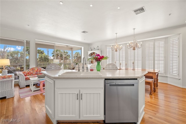 11533 Andy Rosse Ln, Captiva, FL 33924 - kitchen featuring stainless steel dishwasher, a sink, light wood-style flooring, a chandelier, and a center island with sink