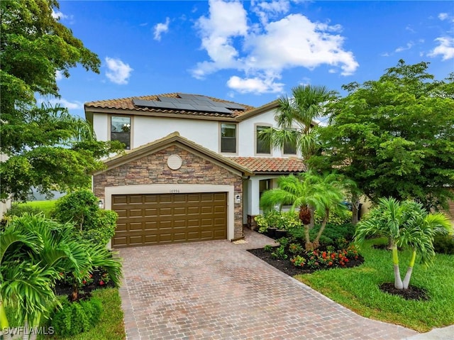 10996 Cherry Laurel Dr, Fort Myers, FL 33912 - mediterranean / spanish home featuring stucco siding, solar panels, stone siding, decorative driveway, and a tiled roof