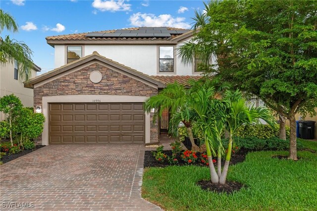 10996 Cherry Laurel Dr, Fort Myers, FL 33912 - view of front of house featuring stucco siding, roof mounted solar panels, a tile roof, and driveway