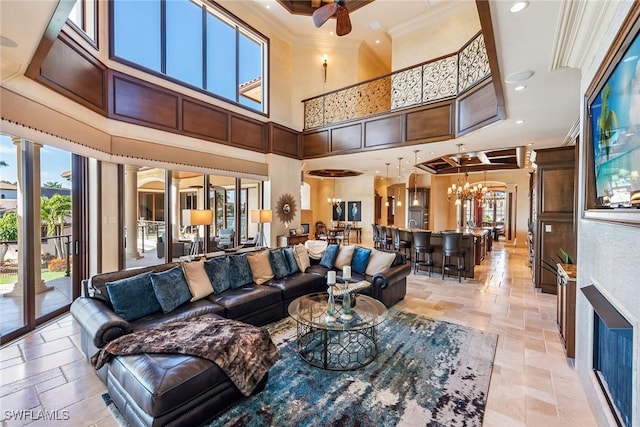 1547 Caxambas Ct, Marco Island, FL 34145 - living room featuring stone tile floors, a towering ceiling, a chandelier, plenty of natural light, and crown molding