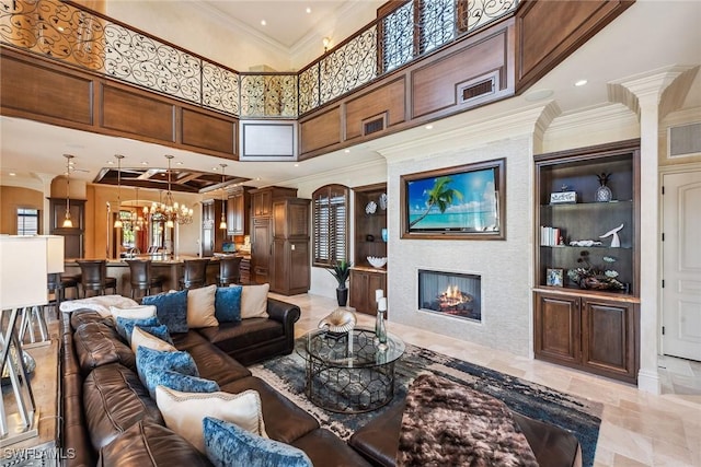 1547 Caxambas Ct, Marco Island, FL 34145 - living room featuring ornamental molding, a glass covered fireplace, a high ceiling, a chandelier, and recessed lighting