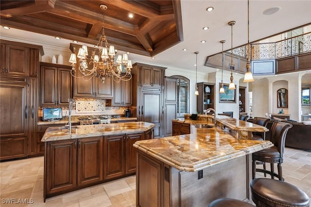 1547 Caxambas Ct, Marco Island, FL 34145 - kitchen with a large island, a sink, coffered ceiling, a chandelier, and crown molding