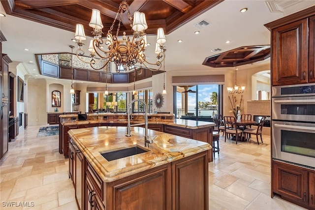 1547 Caxambas Ct, Marco Island, FL 34145 - kitchen with a large island with sink, a chandelier, double oven, coffered ceiling, and a sink