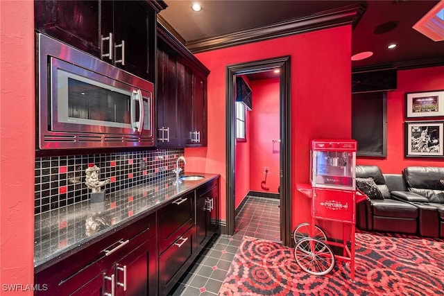 1547 Caxambas Ct, Marco Island, FL 34145 - kitchen with crown molding, stainless steel microwave, a sink, tasteful backsplash, and dark stone countertops