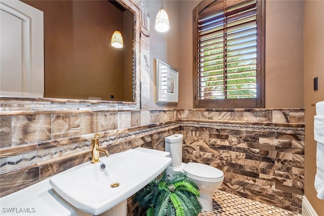 1547 Caxambas Ct, Marco Island, FL 34145 - half bathroom featuring a sink, toilet, tile walls, a wainscoted wall, and tile patterned flooring