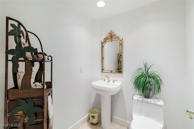 1060 Borghese Ln Unit 1005, Naples, FL 34114 - half bathroom with toilet, baseboards, and a sink