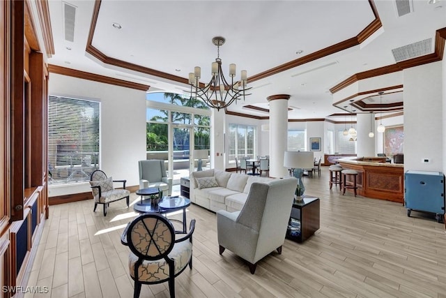 1060 Borghese Ln Unit 1005, Naples, FL 34114 - living area with a raised ceiling, crown molding, ornate columns, a chandelier, and light wood-type flooring