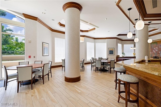 1060 Borghese Ln Unit 1005, Naples, FL 34114 - dining space with ornate columns, plenty of natural light, crown molding, light wood-style floors, and a raised ceiling