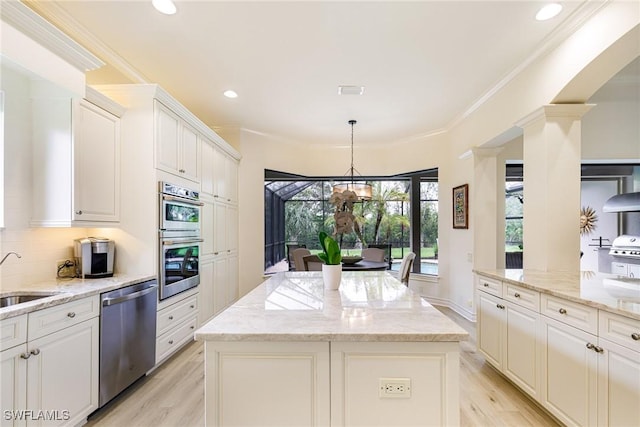 20081 Chapel Trce, Estero, FL 33928 - kitchen with appliances with stainless steel finishes, a kitchen island, light wood-type flooring, decorative backsplash, and recessed lighting