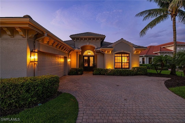20081 Chapel Trce, Estero, FL 33928 - mediterranean / spanish house with french doors, stucco siding, a garage, and decorative driveway