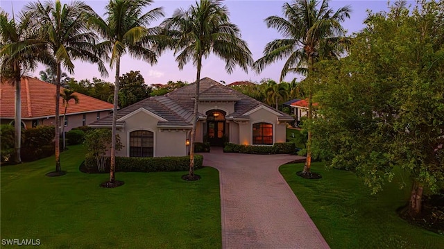 20081 Chapel Trce, Estero, FL 33928 - view of front of house with decorative driveway, a garage, a front lawn, and stucco siding