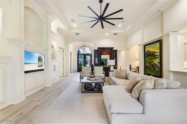20081 Chapel Trce, Estero, FL 33928 - living room with light wood-type flooring, a ceiling fan, a raised ceiling, ornamental molding, and arched walkways