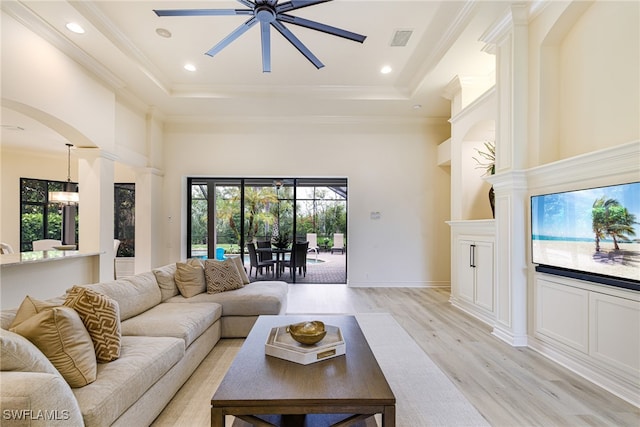 20081 Chapel Trce, Estero, FL 33928 - living room with a ceiling fan, light wood-style flooring, a tray ceiling, decorative columns, and a towering ceiling