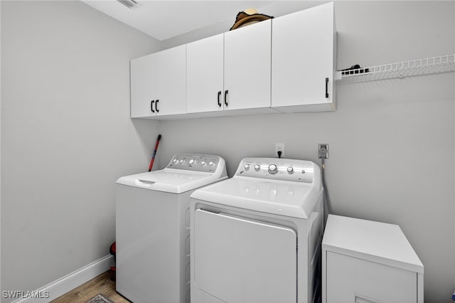 24769 Paradise Rd, Bonita Springs, FL 34135 - washroom featuring cabinet space, washing machine and clothes dryer, and wood finished floors
