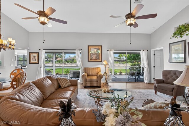 24769 Paradise Rd, Bonita Springs, FL 34135 - living area featuring ceiling fan, wood finished floors, high vaulted ceiling, and a chandelier