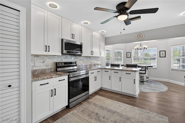 24769 Paradise Rd, Bonita Springs, FL 34135 - kitchen featuring stainless steel appliances, white cabinetry, tasteful backsplash, and wood finished floors
