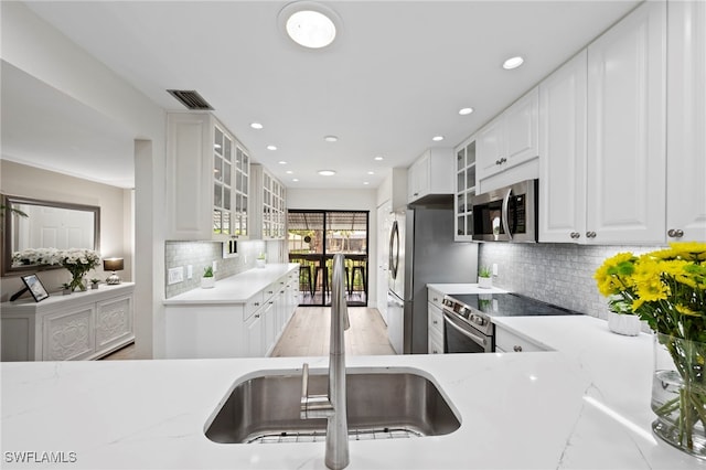 15444 Admiralty Cir Unit 10, North Fort Myers, FL 33917 - kitchen with appliances with stainless steel finishes, a sink, tasteful backsplash, glass insert cabinets, and recessed lighting