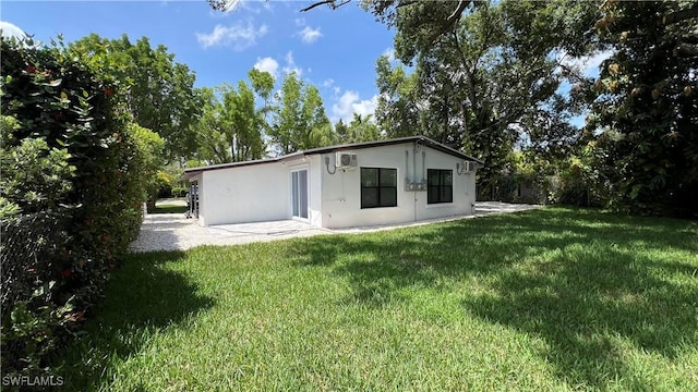 2615/2617 Michigan Ave, Fort Myers, FL 33916 - rear view of property featuring stucco siding, a yard, a wall mounted AC, and a patio