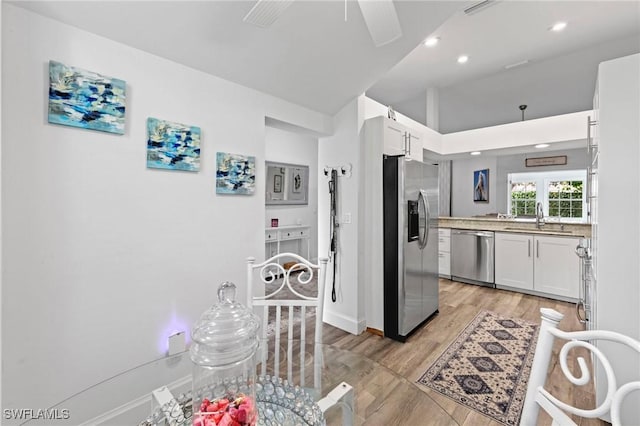 10811 Breaker Ln, Naples, FL 34109 - kitchen featuring appliances with stainless steel finishes, a sink, light wood-type flooring, white cabinetry, and recessed lighting