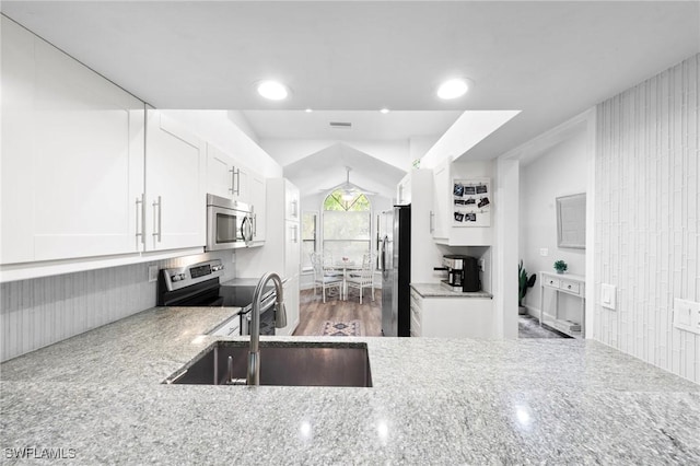 10811 Breaker Ln, Naples, FL 34109 - kitchen featuring stainless steel appliances, a sink, light stone countertops, white cabinetry, and recessed lighting