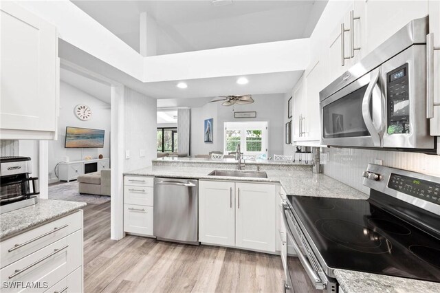 10811 Breaker Ln, Naples, FL 34109 - kitchen featuring stainless steel appliances, a sink, lofted ceiling, a ceiling fan, and light wood-type flooring