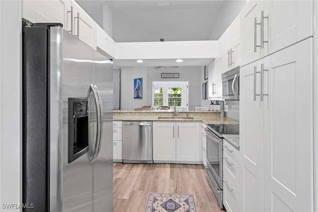 10811 Breaker Ln, Naples, FL 34109 - kitchen featuring stainless steel appliances, a sink, white cabinetry, light wood-type flooring, and light stone countertops