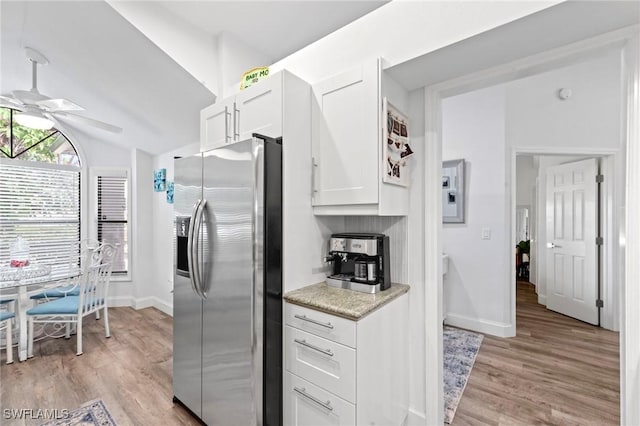 10811 Breaker Ln, Naples, FL 34109 - kitchen featuring stainless steel refrigerator with ice dispenser, ceiling fan, white cabinetry, light wood-style floors, and light countertops