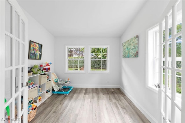 10811 Breaker Ln, Naples, FL 34109 - game room with french doors, wood finished floors, baseboards, and lofted ceiling