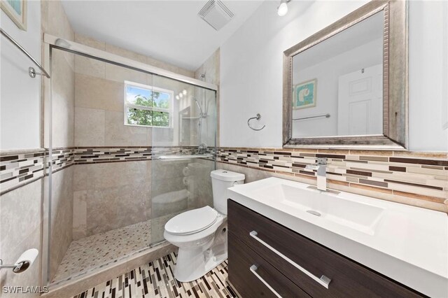 10811 Breaker Ln, Naples, FL 34109 - full bath featuring tile walls, toilet, vanity, and a stall shower