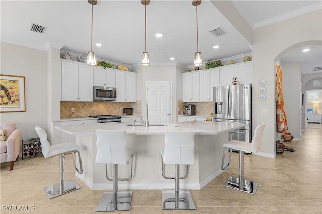 10498 Casella Way Unit 202, Fort Myers, FL 33913 - kitchen featuring appliances with stainless steel finishes, ornamental molding, a sink, arched walkways, and backsplash