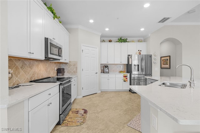 10498 Casella Way Unit 202, Fort Myers, FL 33913 - kitchen with stainless steel appliances, a sink, crown molding, arched walkways, and white cabinets