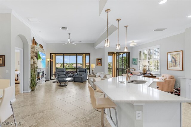 10498 Casella Way Unit 202, Fort Myers, FL 33913 - kitchen with a sink, open floor plan, crown molding, light tile patterned floors, and a glass covered fireplace