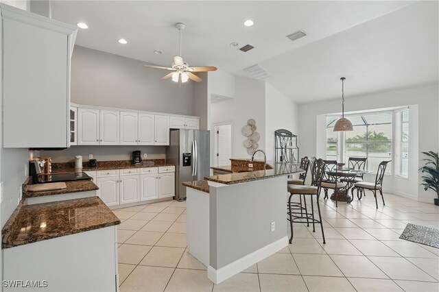5408 SW 26th Ct, Cape Coral, FL 33914 - kitchen with stainless steel fridge, high vaulted ceiling, light tile patterned flooring, white cabinetry, and ceiling fan