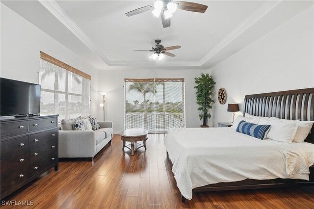5408 SW 26th Ct, Cape Coral, FL 33914 - bedroom featuring a raised ceiling, dark wood-style flooring, a ceiling fan, crown molding, and access to exterior