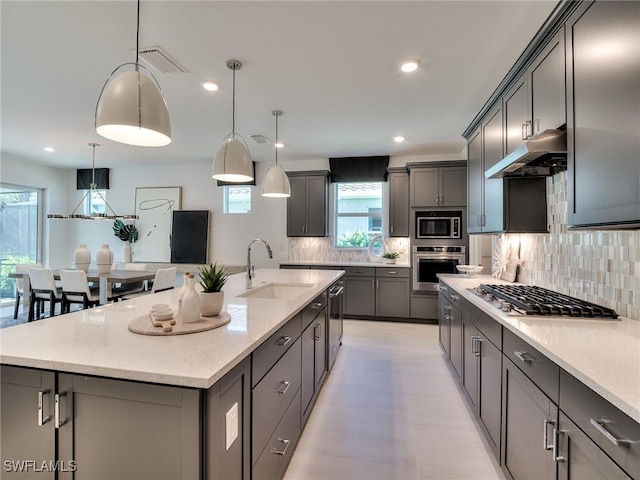 17304 Green Buttonwood Way N, Fort Myers, FL 33917 - kitchen with stainless steel appliances, a sink, under cabinet range hood, healthy amount of natural light, and recessed lighting