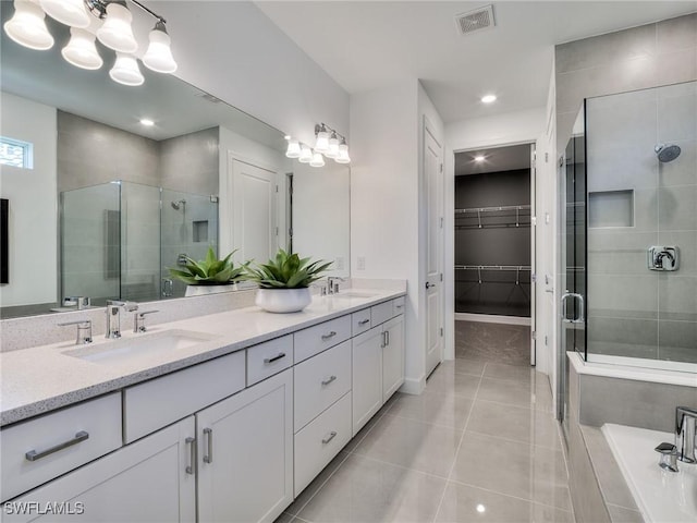 17304 Green Buttonwood Way N, Fort Myers, FL 33917 - bathroom with a shower stall, double vanity, a walk in closet, tile patterned floors, and a bath