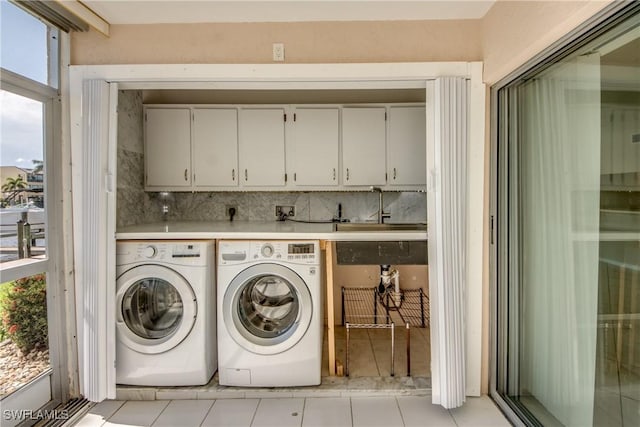 4013 SE 19th Pl Unit 101, Cape Coral, FL 33904 - washroom with cabinet space, washer and clothes dryer, and light tile patterned flooring