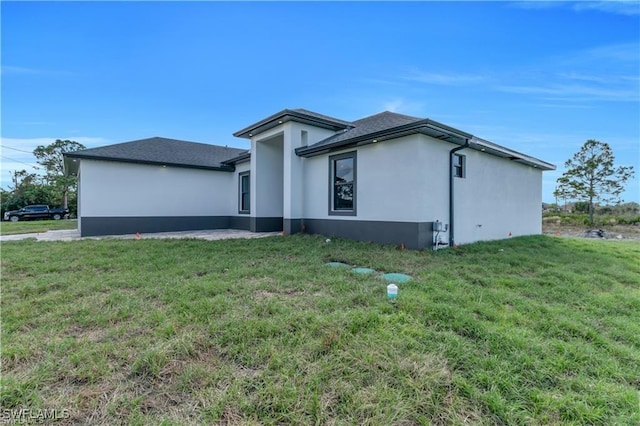 1057 Brenton Ave, Lehigh Acres, FL 33974 - view of side of home with stucco siding and a yard